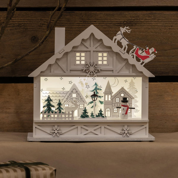 Christmas White Wooden House with Santa On The Roof Scene
